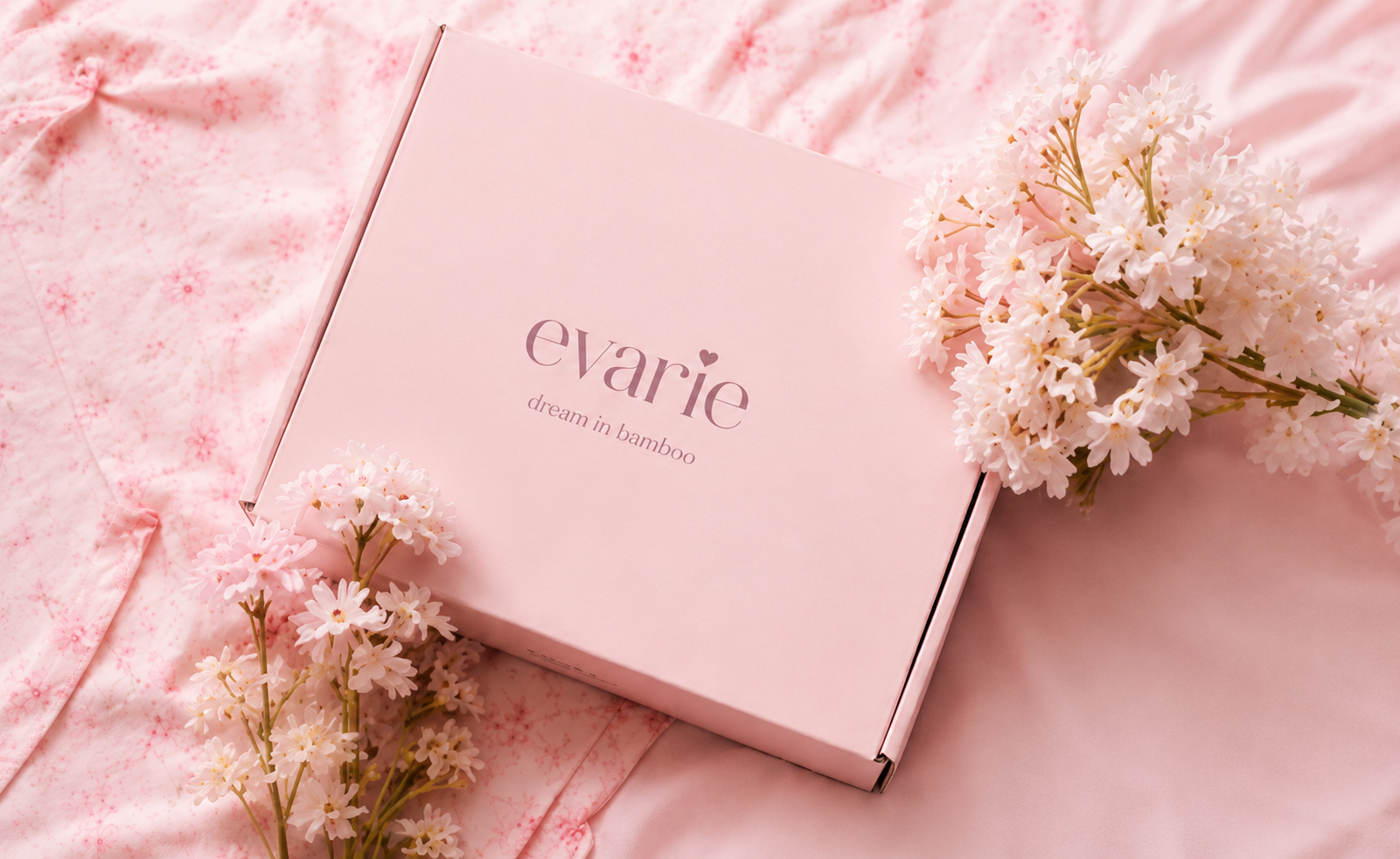 evarie pink gift box on satin sheets with daisies